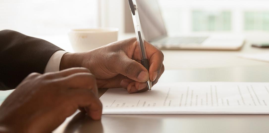 A photo of a hand signing a document